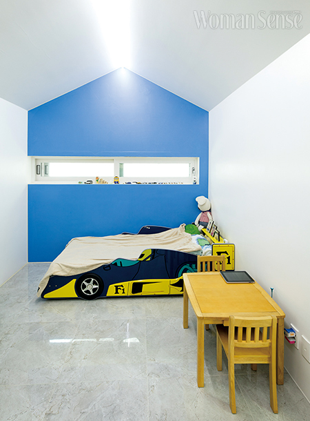 박공지붕 모양을 살린 벽에 블루 컬러 페인팅을 해 생기 넘치는 우인이의 방.
