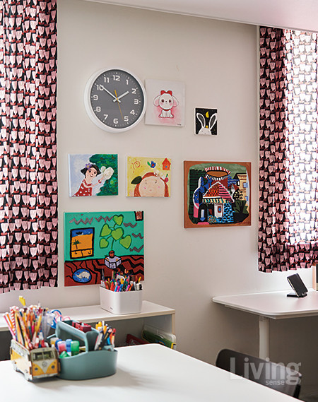 창문 사이 빈 벽에 아이들의 그림과 예술 작품을 함께 배치했다. 커튼은 키티버니포니 제품.