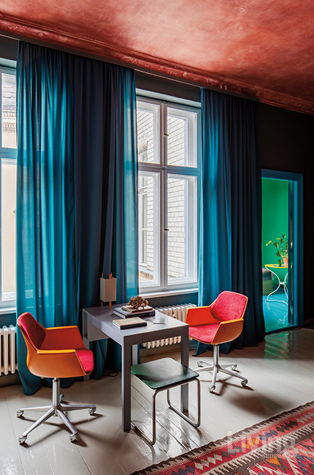 붉은색 천장, 초록색 벽, 붉은색 가구가 조화를 이루는 창가. 커튼마저 빛이 투과하는 하늘색 천으로 제작했다. 회색 테이블은 마르틴 홀자펠이 디자인한 제품. 윌칸(wilkhahn) 오렌지색 의자는 현재 단종된 1970년대 빈티지 제품.  